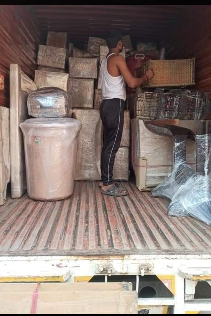 Worker arranging packed goods inside truck